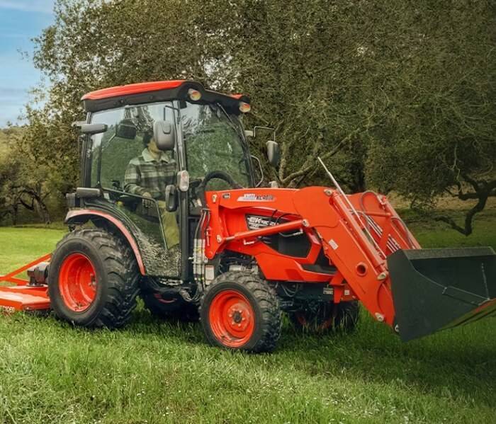Efficient Grass Cutting with Riding Mower Professional gardener mowing the grass with a riding mower in a residential backyard.
