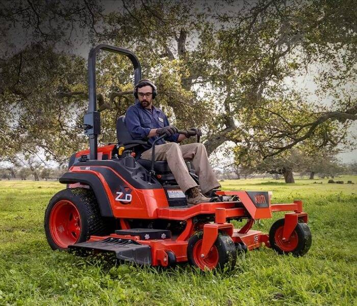 Lawn Mowing Service with Gas Mower Landscaping professional mowing a well-kept lawn with a riding mower.